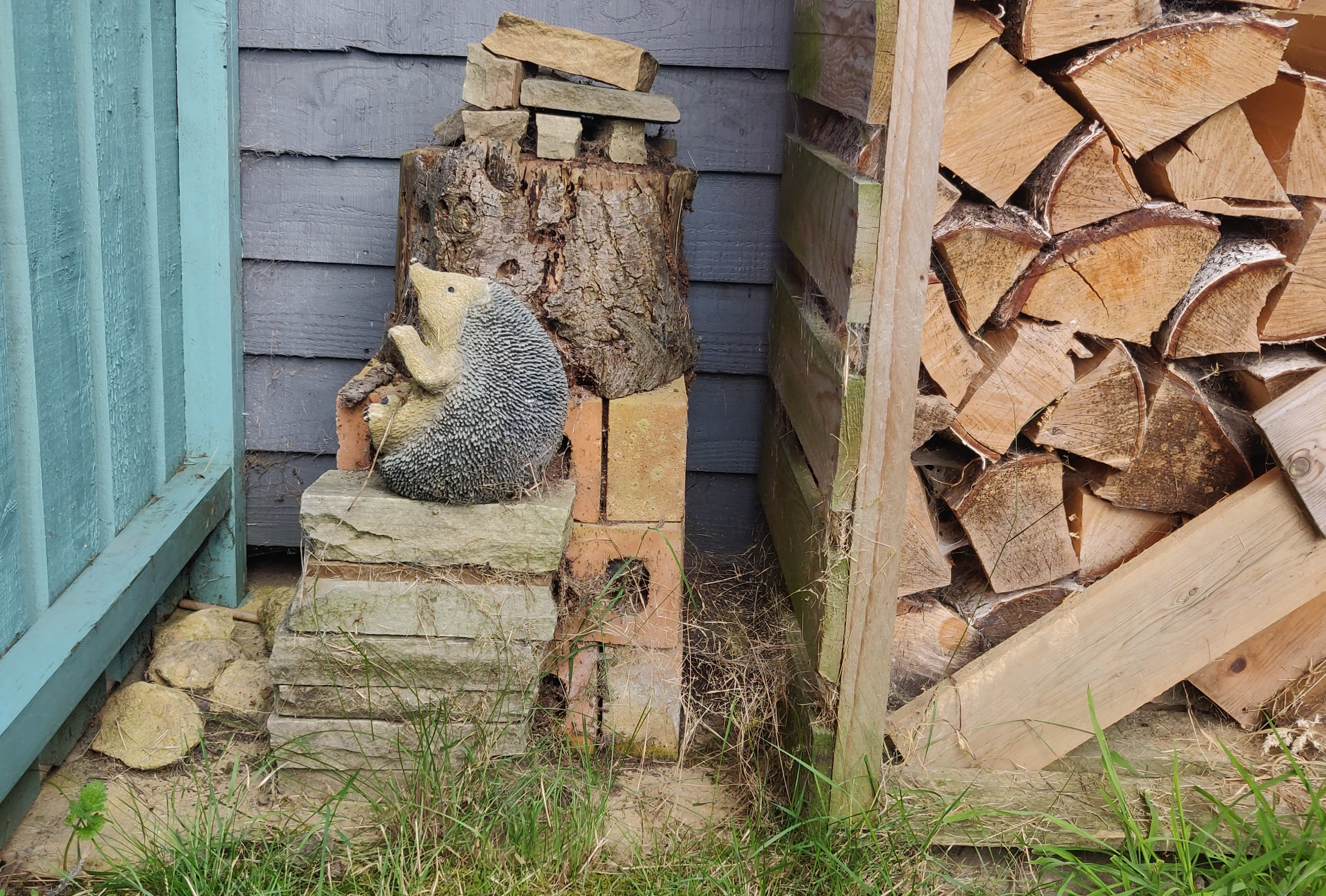 Bug house made with bricks, stones, logs and pine cones