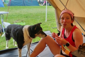Gemma Scougal scoffing her face inbetwwen laps of Endure24 2019 Leeds whilst Lance dog is staring and drooling