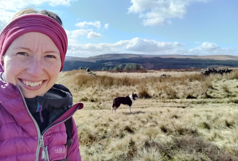 Gemma with down jacket and buff somewhere in the Peak District