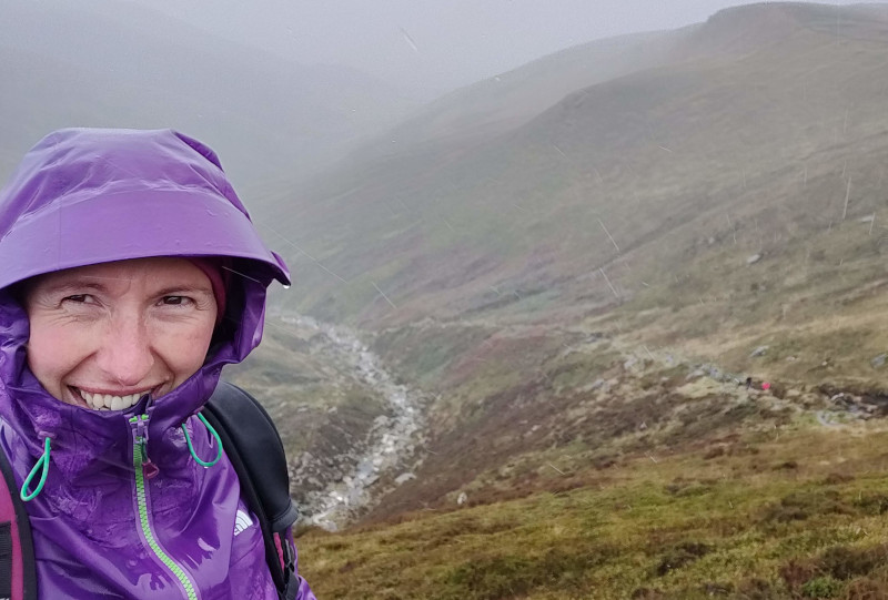 Gemma in torrential rain leading a group of clients up Kinder, Peak District.